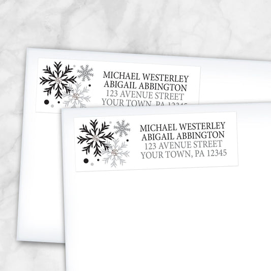 2 Winter Black Silver Snowflake Address Labels shown on white envelopes on a marble surface