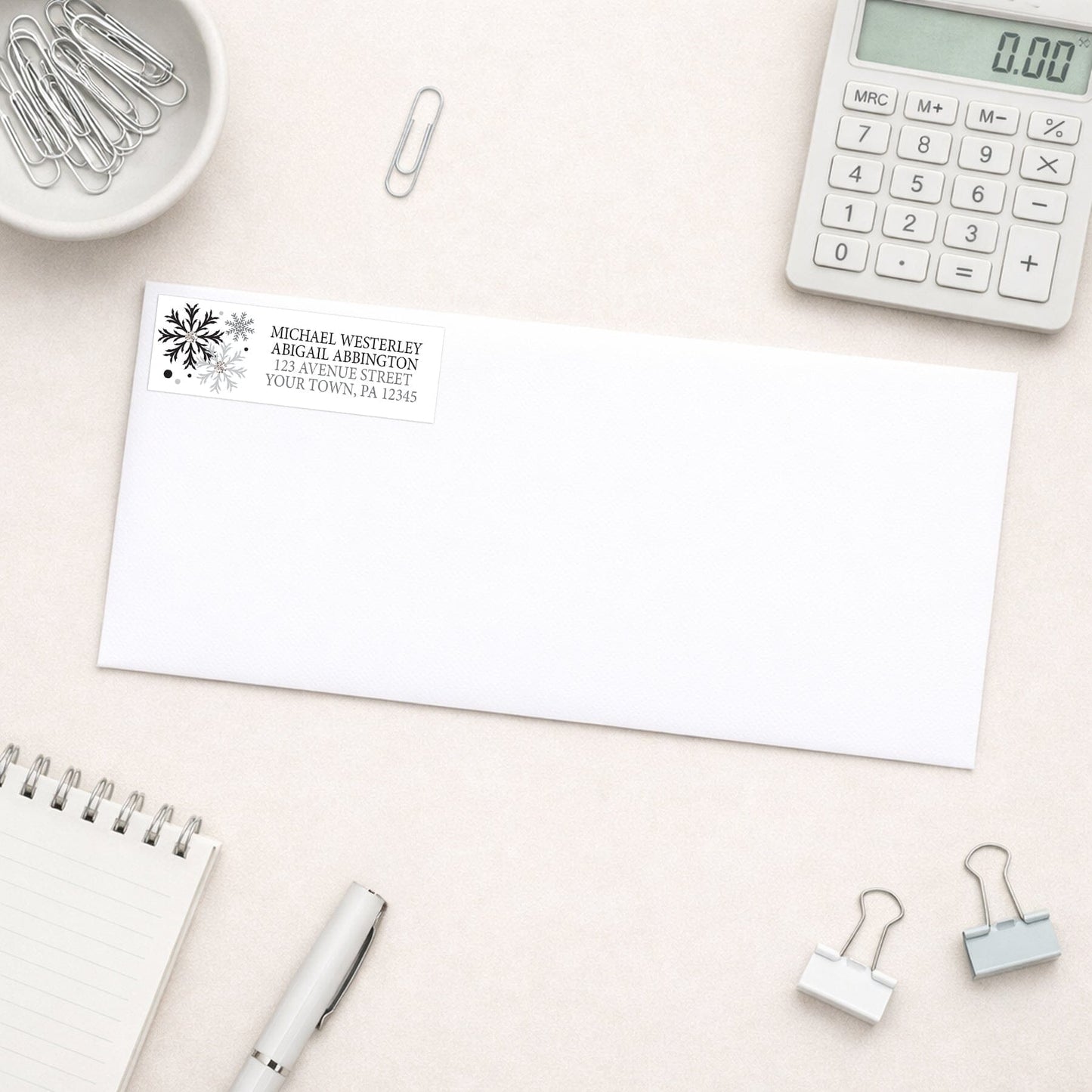 Winter Black Silver Snowflake Address Label shown on a white envelope with everyday office supplies
