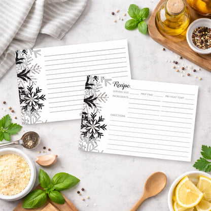Two Winter Black Silver Snowflake Recipe Cards on a kitchen counter with ingredients.