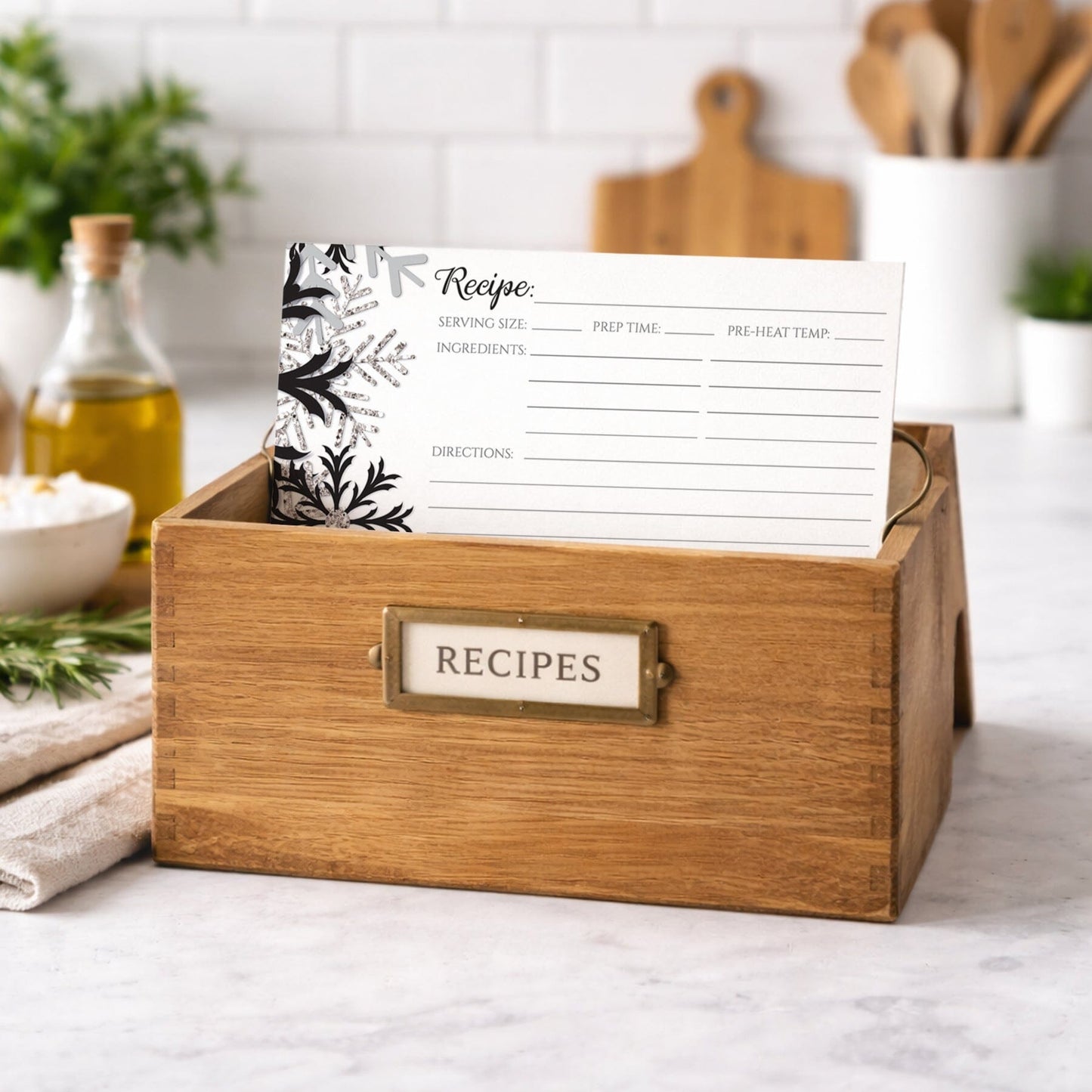 Wooden recipe box with a Winter Black Silver Snowflake Recipe Card inside, set against a kitchen background.