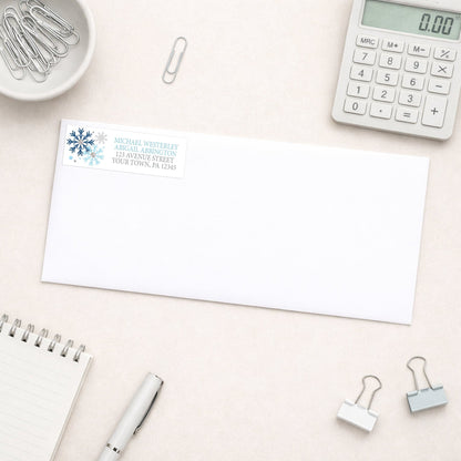 Winter Blue Silver Snowflake Address Label shown on a white envelope with everyday office supplies