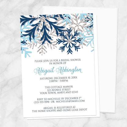 Winter Blue Silver Snowflake Bridal Shower Invitation shown on a marble surface with a white envelope.