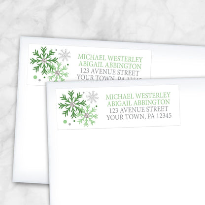 2 Winter Green Silver Snowflake Address Labels shown on white envelopes on a marble surface