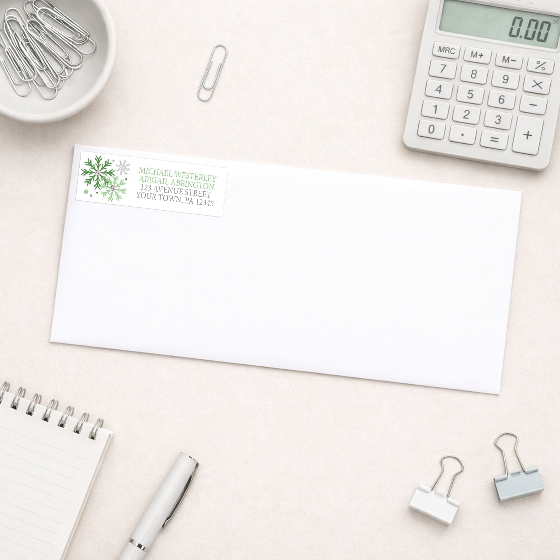 Winter Green Silver Snowflake Address Label shown on a white envelope with office supplies