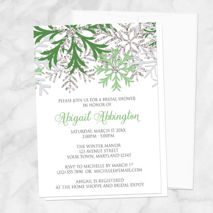 Winter Green Silver Snowflake Bridal Shower Invitation shown on a marble surface with a white envelope.