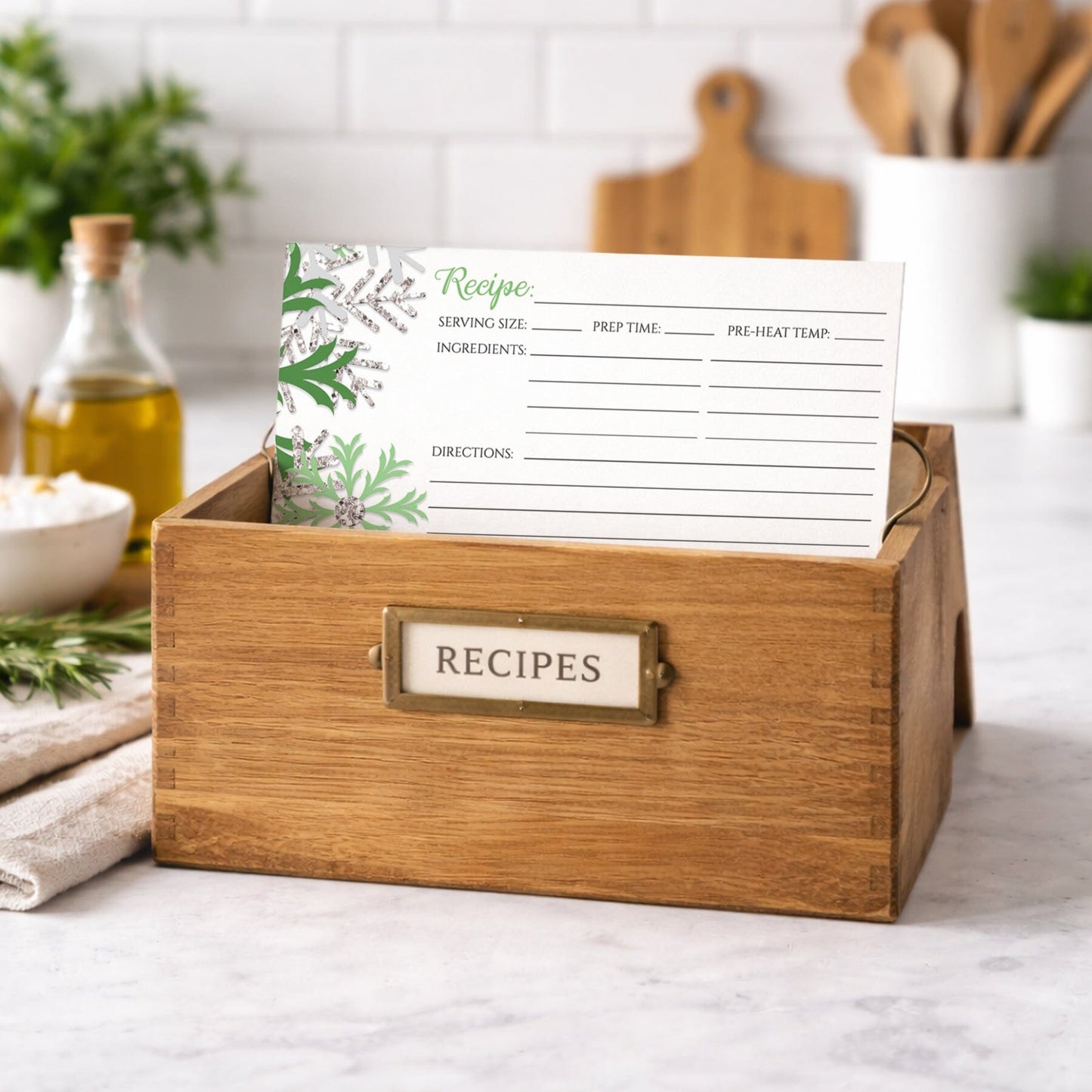 Wooden recipe box with a Winter Green Silver Snowflake Recipe Card inside, set against a kitchen background.