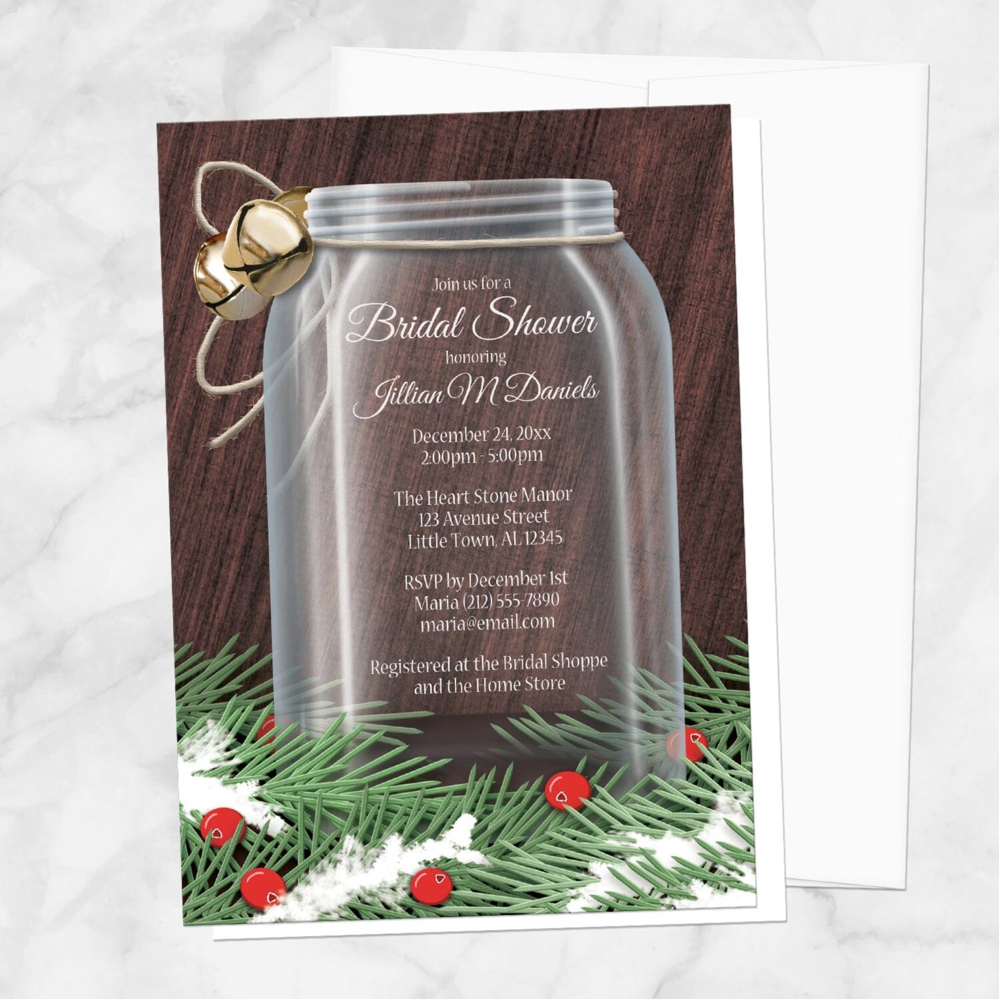 Winter Mason Jar Pine Boughs Bridal Shower Invitation shown on a marble surface with a white envelope.