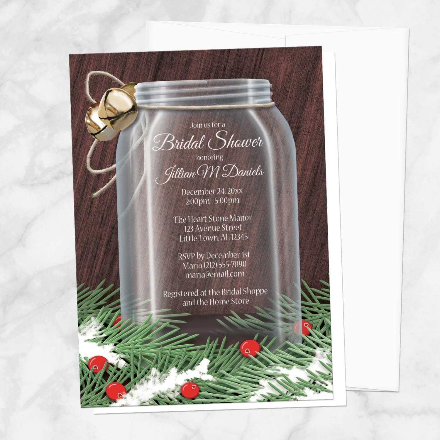 Winter Mason Jar Pine Boughs Bridal Shower Invitation shown on a marble surface with a white envelope.