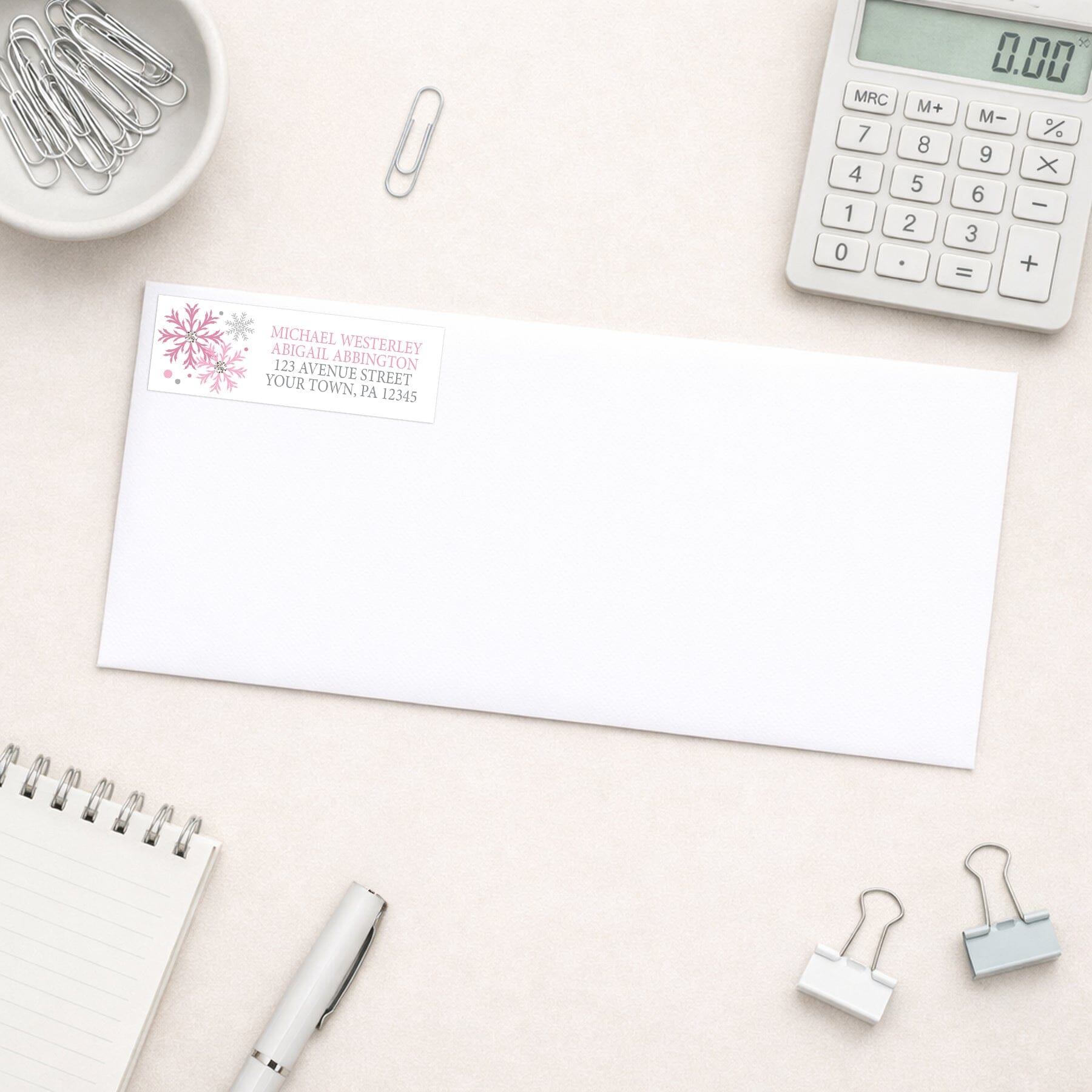 Winter Pink Silver Snowflake Address Label shown on a white envelope with everyday office supplies