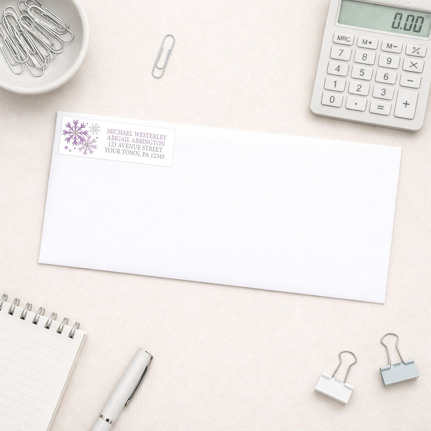 Winter Purple Silver Snowflake Address Label shown on a white envelope with everyday office supplies