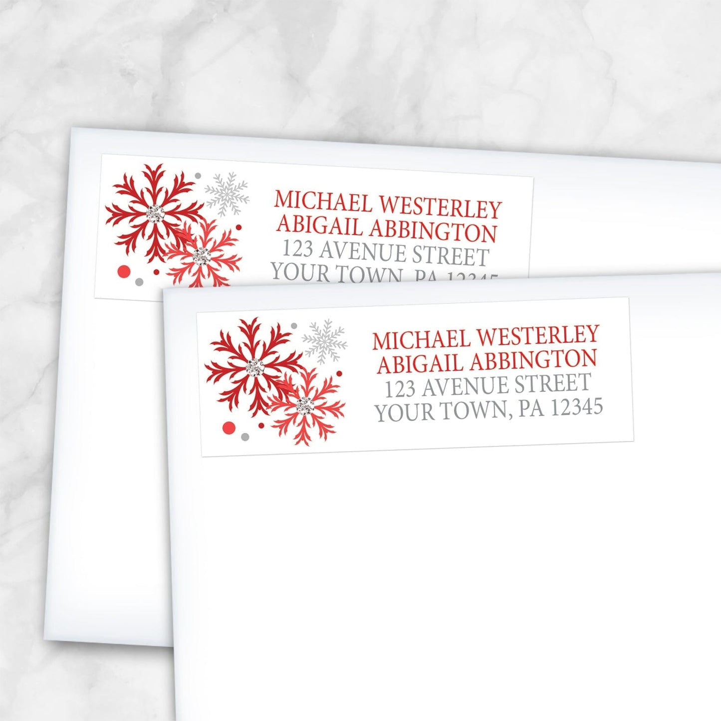 2 Winter Red Silver Snowflake Address Labels shown on white envelopes on a marble surface