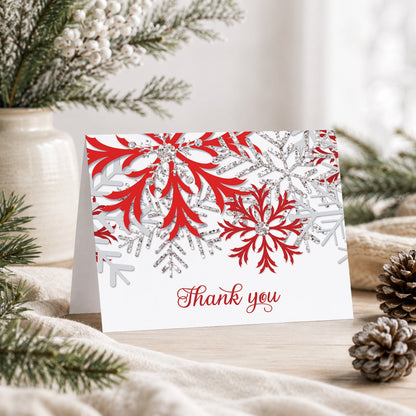 Winter Red Silver Snowflake Thank You Card shown on a tabletop with a vase, winter greenery, and pine cones.