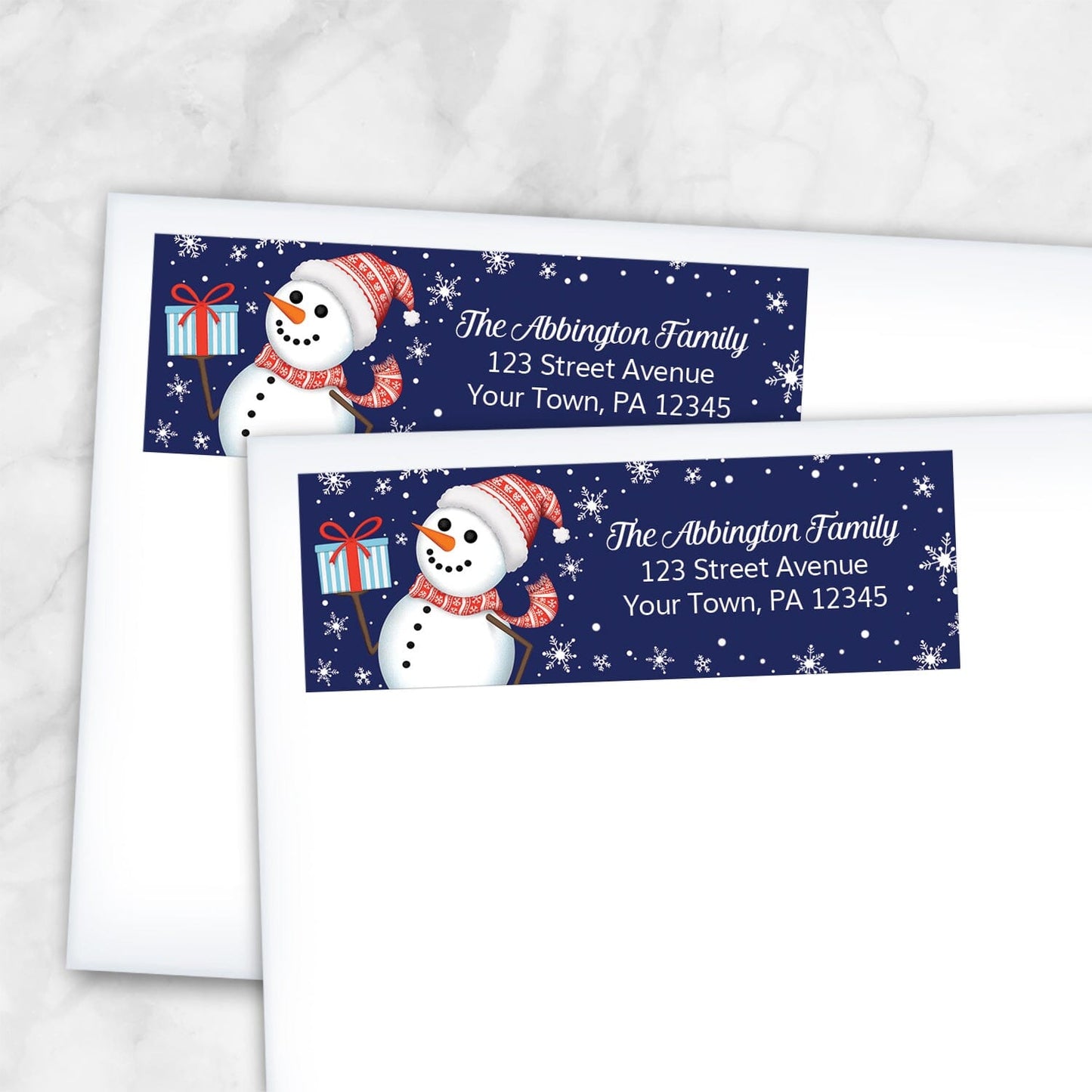 Two Christmas-themed address labels with snowmen on white envelopes