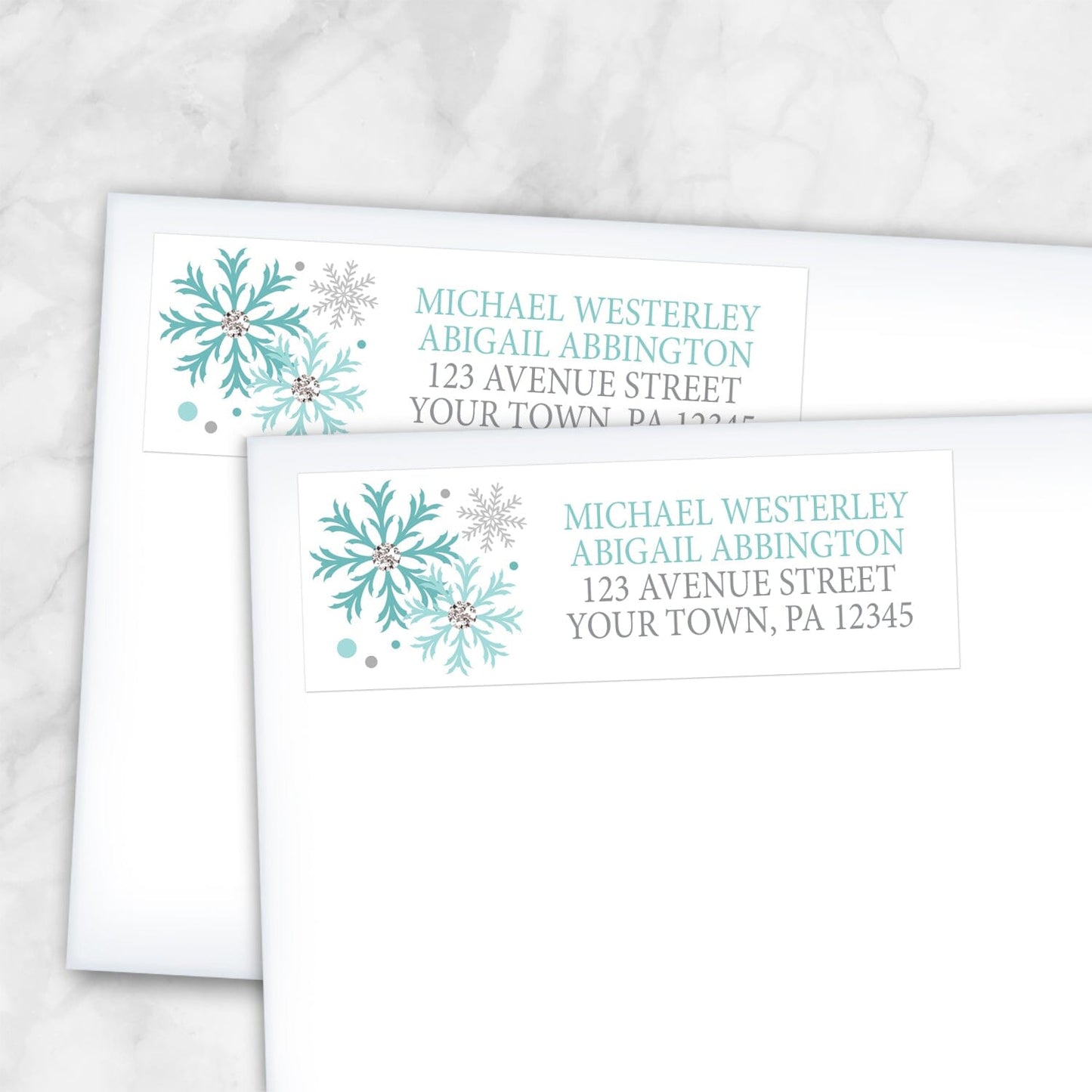 2 Winter Teal Silver Snowflake Address Labels shown on white envelopes on a marble surface