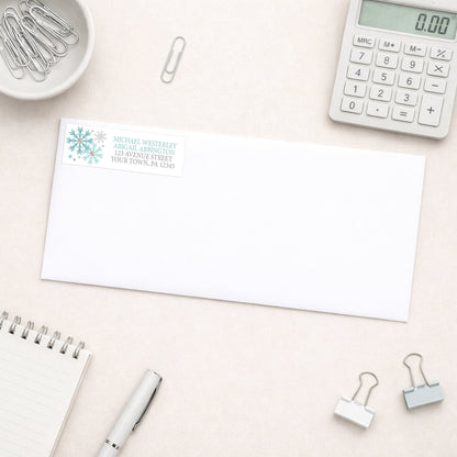 Winter Teal Silver Snowflake Address Label shown on a white envelope with everyday office supplies