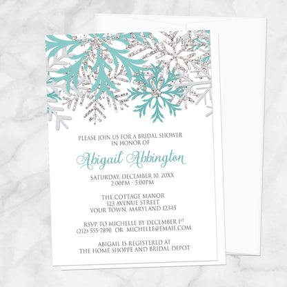Winter Teal Silver Snowflake Bridal Shower Invitation shown with a white envelope on a marble surface.
