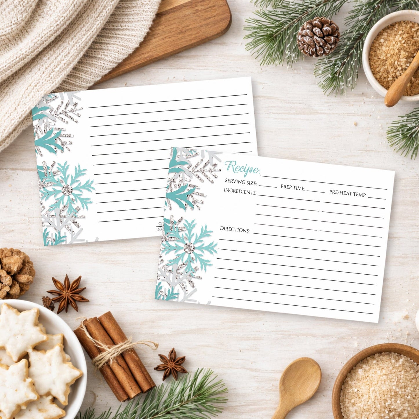 Two Winter Teal Silver Snowflake Recipe Cards on a festive winter table with holiday cookies and spices.