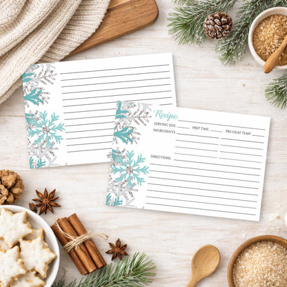 Two Winter Teal Silver Snowflake Recipe Cards on a festive winter table with holiday cookies and spices.