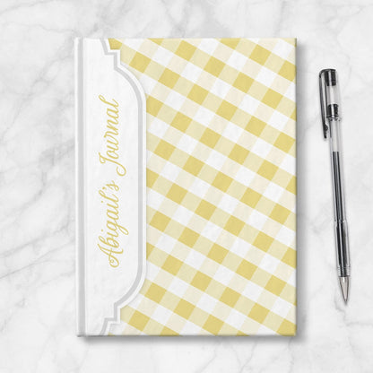 Personalized Yellow Gingham Journal at Artistically Invited. Image shows the book on a countertop next to a pen.