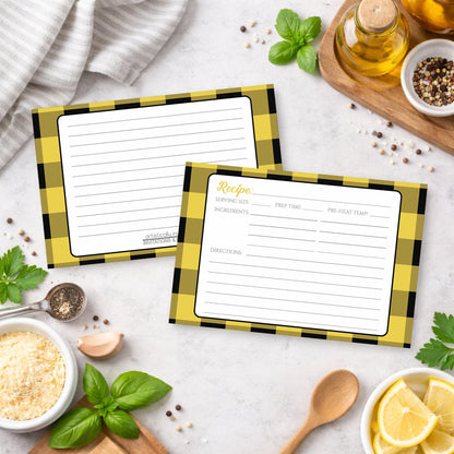 Two Yellow and Black Buffalo Plaid Recipe Cards with checkered borders on a kitchen counter with ingredients.