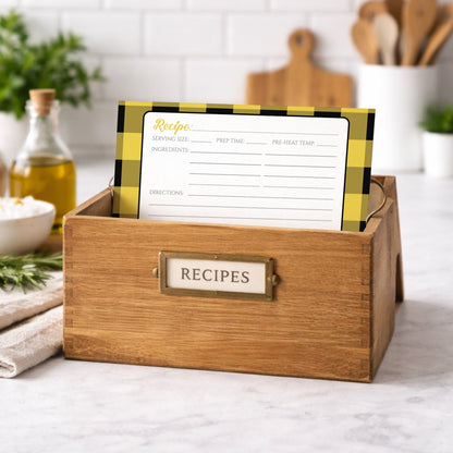Wooden recipe box with a Yellow and Black Buffalo Plaid Recipe Card inside, set against a kitchen background.
