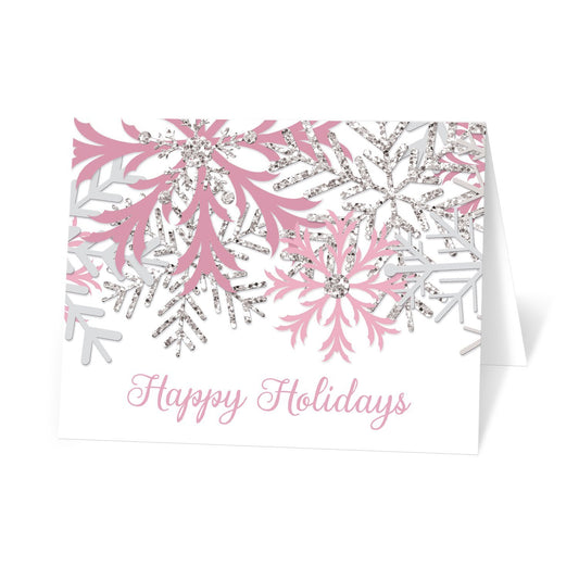 Winter Pink Silver Snowflake Holiday Cards at Artistically Invited. Modern winter pink holiday cards designed with pink, light gray, and silver glitter-illustrated snowflakes over a white background. 'Happy Holidays' is printed in a pink script font over the white below the snowflakes. 
